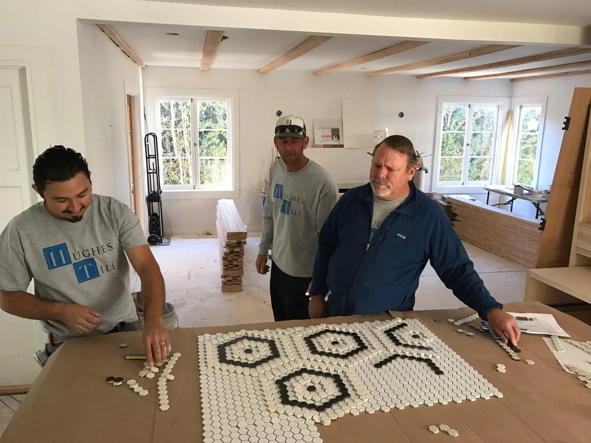 Willy and the Hughes Tile crew laying out a black and white hexagon penny-tile mosaic