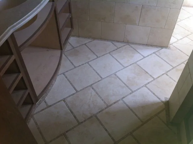 Diagonal limestone bathroom floor tile with a matching tiled wall