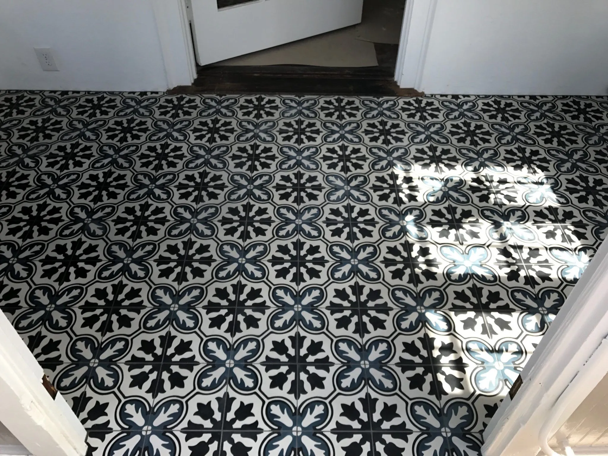 Black and white floral-pattern cement tile floor