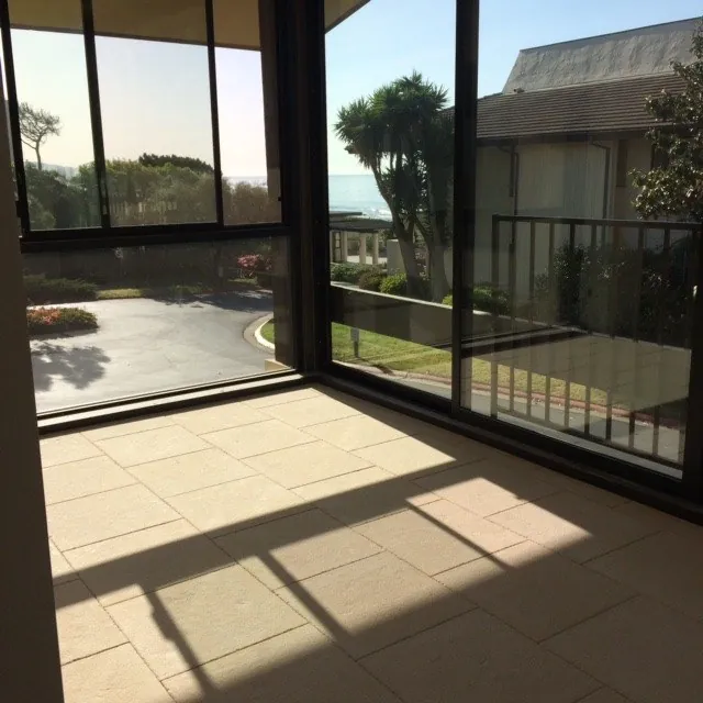 Large-format stone floor tile in a sunroom with floor-to-ceiling windows