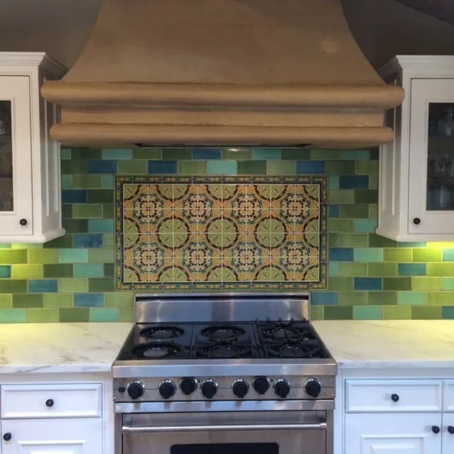 Tile backsplash with a hand-painted Spanish tile mural behind a range