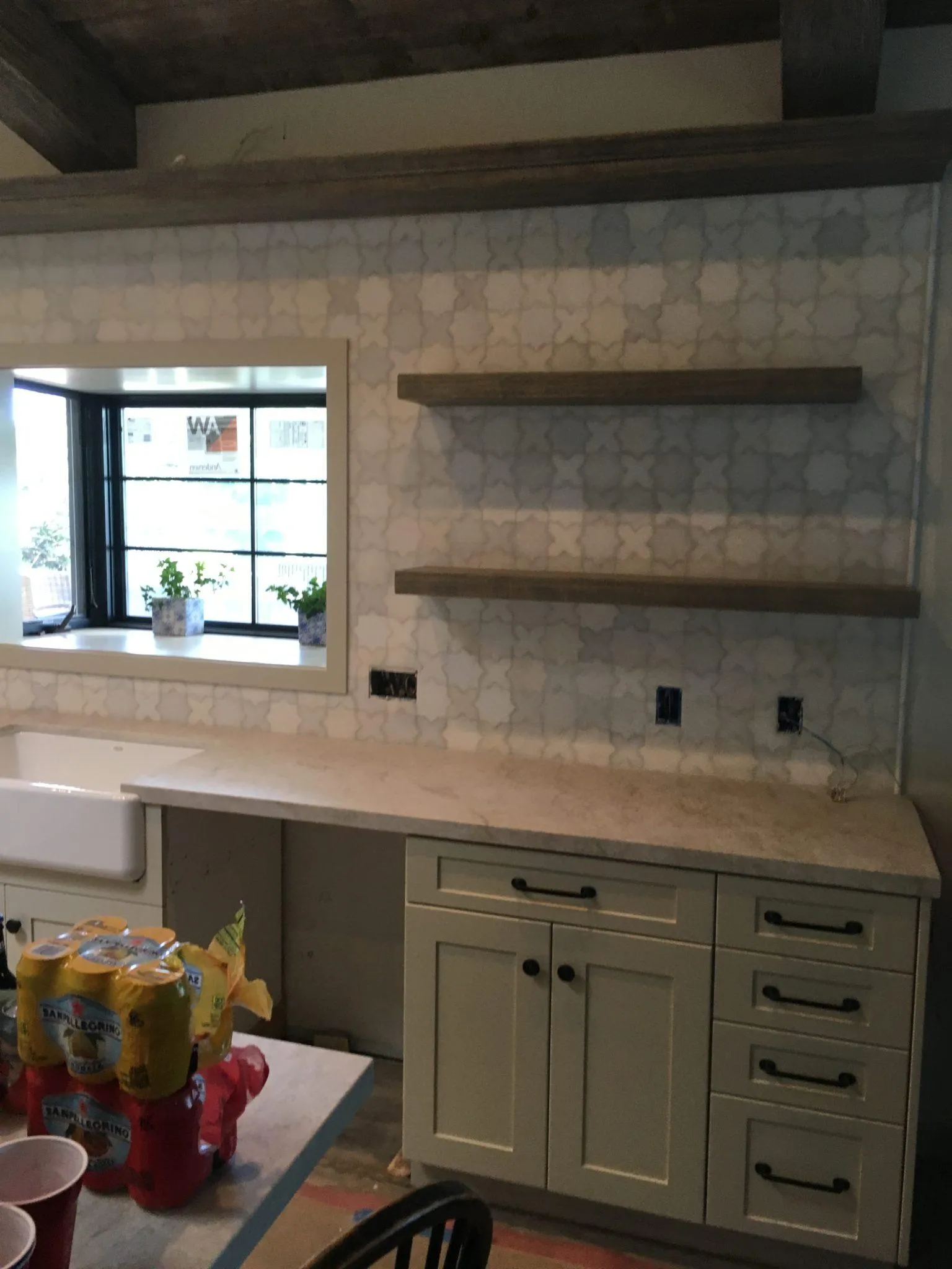 Kitchen wall of pale gray octagon tile with floating wood shelves